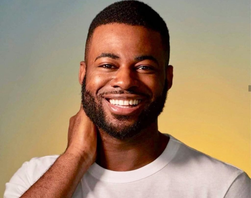 Photograph of LGBT correspondent Ben Hunte in white t-shirt, smiling